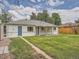 Home's back exterior features a well-kept lawn and charming covered patio, and convenient access doors at 1245 Troy St, Aurora, CO 80011