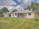 The back of the house has a covered patio with a lush lawn and a storage shed for tools and equipment at 1245 Troy St, Aurora, CO 80011