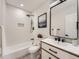 Bright bathroom featuring white tile, modern fixtures, and an enclosed shower and tub at 1245 Troy St, Aurora, CO 80011