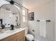 Stylish bathroom featuring an ornate wood vanity, modern fixtures, and an arched mirror at 1245 Troy St, Aurora, CO 80011