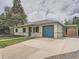 A single-story home with a blue door, blue garage door and an extended carport in a residential area at 1245 Troy St, Aurora, CO 80011