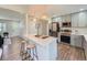 Contemporary kitchen with stainless steel appliances, a kitchen island with bar seating and open concept to living area at 1245 Troy St, Aurora, CO 80011