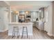 Charming kitchen with stainless steel appliances, eat-in bar, light gray cabinets, and wood floors at 1245 Troy St, Aurora, CO 80011