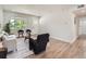 Well-lit living room with hardwood floors, neutral furniture and a large window overlooking the front yard at 1245 Troy St, Aurora, CO 80011