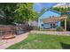 Charming backyard featuring a well-kept lawn, a pergola-covered patio, and a blue house at 2645 Osceola St, Denver, CO 80212