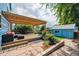 Landscaped backyard with a pergola-covered patio, lush greenery, and hardscaped walkways at 2645 Osceola St, Denver, CO 80212