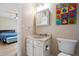 Cozy bathroom view from the bedroom with a vanity, toilet, and colorful decor at 2645 Osceola St, Denver, CO 80212