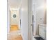 Hallway with hardwood floors with multiple doors leading to other rooms and a partial view of a bathroom at 2645 Osceola St, Denver, CO 80212