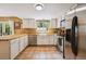 Spacious kitchen with stainless steel appliances, white cabinets, and tile flooring, flooded with natural light at 2645 Osceola St, Denver, CO 80212