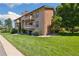 Charming condo building with well-maintained landscaping and balconies on a sunny day at 420 Zang St # 3-208, Lakewood, CO 80228