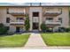 Well-maintained condo building featuring a central entrance and lush green lawn at 420 Zang St # 3-208, Lakewood, CO 80228