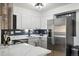 Bright kitchen featuring white cabinets, stainless steel appliances, and stylish subway tile backsplash at 420 Zang St # 3-208, Lakewood, CO 80228