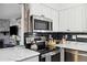 Close up shot of kitchen with stainless steel appliances and white cabinets with dark hardware at 420 Zang St # 3-208, Lakewood, CO 80228