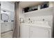 Convenient laundry area features a stacked washer and dryer with storage shelf and is next to the updated bathroom at 420 Zang St # 3-208, Lakewood, CO 80228