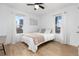 Bright bedroom with hardwood floors, two windows, and neutral decor at 6005 E Iowa Ave, Denver, CO 80224