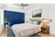 Comfortable bedroom features ceiling fan, wood floors, and an attractive accent wall at 6005 E Iowa Ave, Denver, CO 80224