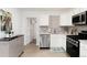 Bright kitchen with stainless steel appliances, white cabinets, and decorative backsplash at 6005 E Iowa Ave, Denver, CO 80224