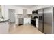 Modern kitchen featuring stainless steel appliances, white cabinets, and stylish backsplash at 6005 E Iowa Ave, Denver, CO 80224