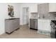 Bright kitchen features stainless appliances, white cabinets, stylish backsplash and breakfast nook at 6005 E Iowa Ave, Denver, CO 80224