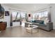Bright and airy living room with large windows, stylish furniture, and hardwood floors at 6005 E Iowa Ave, Denver, CO 80224