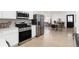 Open-concept kitchen flows to dining area and living room with stainless appliances at 6005 E Iowa Ave, Denver, CO 80224