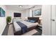 Modern main bedroom with large TV, stylish decor, and plush carpet at 6005 E Iowa Ave, Denver, CO 80224