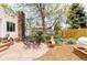 Relaxing backyard with stone patio, outdoor dining, mature trees, and a cozy hammock at 1634 S King St, Denver, CO 80219