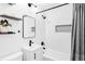 Modern bathroom features black fixtures, tiled shower-tub combo and a sleek vanity at 1634 S King St, Denver, CO 80219