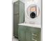 Bathroom with a modern green vanity, white marble countertop, and a round mirror with washer/dryer reflection at 1634 S King St, Denver, CO 80219