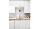 Close-up of a stylish kitchen featuring neutral backsplash, wooden countertops, and white cabinets at 1634 S King St, Denver, CO 80219