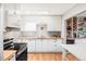 Modern kitchen with white cabinets, wooden countertops, and stainless-steel appliances at 1634 S King St, Denver, CO 80219