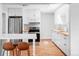 Bright kitchen features stainless steel appliances, white cabinets, and an open breakfast bar at 1634 S King St, Denver, CO 80219