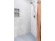 Elegant walk-in shower features sleek tiling, hexagon floor, built-in niche and modern shower head at 1634 S King St, Denver, CO 80219