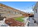 Fenced back yard features stone retaining wall and string lights at 7745 Grant St, Denver, CO 80229