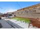 Backyard with some snow, a retaining wall, and a green patch of grass at 7745 Grant St, Denver, CO 80229