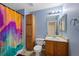 Full bath with a shower/tub combo with colorful curtain and storage at 7745 Grant St, Denver, CO 80229