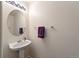 Powder room with pedestal sink, decorative mirror, and towel rack at 7745 Grant St, Denver, CO 80229