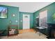 Foyer featuring green walls, a white door, and wood-look floors at 7745 Grant St, Denver, CO 80229