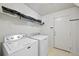 Convenient laundry room featuring a washing machine, dryer, and storage shelving at 7745 Grant St, Denver, CO 80229