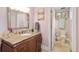 Charming bathroom featuring a vanity with granite countertop, decorative mirror, and toilet room at 2627 E Willamette Ln, Greenwood Village, CO 80121