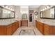 Spacious bathroom with dual vanities, granite countertops, and a walk-in closet entrance at 2627 E Willamette Ln, Greenwood Village, CO 80121