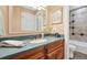 Well-lit bathroom featuring a vanity with wood cabinets, and a tub with decorative tile surround at 2627 E Willamette Ln, Greenwood Village, CO 80121