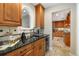 Butler pantry with dark countertops, beverage center, and custom cabinetry at 2627 E Willamette Ln, Greenwood Village, CO 80121