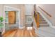 Inviting foyer featuring hardwood floors, staircase with carpet, and an open view of adjacent rooms at 2627 E Willamette Ln, Greenwood Village, CO 80121
