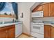 Bright kitchen with white appliances, wooden cabinets, and blue countertops at 2627 E Willamette Ln, Greenwood Village, CO 80121
