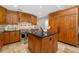 Well-equipped kitchen featuring custom cabinets, stainless steel appliances, a kitchen island, and tile floors at 2627 E Willamette Ln, Greenwood Village, CO 80121