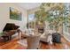 Bright living room with fireplace, piano, and large windows offering natural light at 2627 E Willamette Ln, Greenwood Village, CO 80121