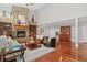Open-concept living room with stone fireplace, hardwood floors, high ceilings, and comfortable seating at 2627 E Willamette Ln, Greenwood Village, CO 80121