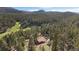 Expansive aerial view of a secluded home nestled in a lush forest with mountain views at 34 Normandy Rd, Evergreen, CO 80439