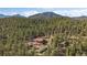 Aerial view of mountain home nestled in the forest with a red roof at 34 Normandy Rd, Evergreen, CO 80439